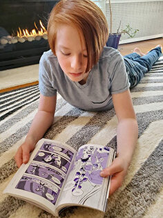A boy reads a graphic novel.
